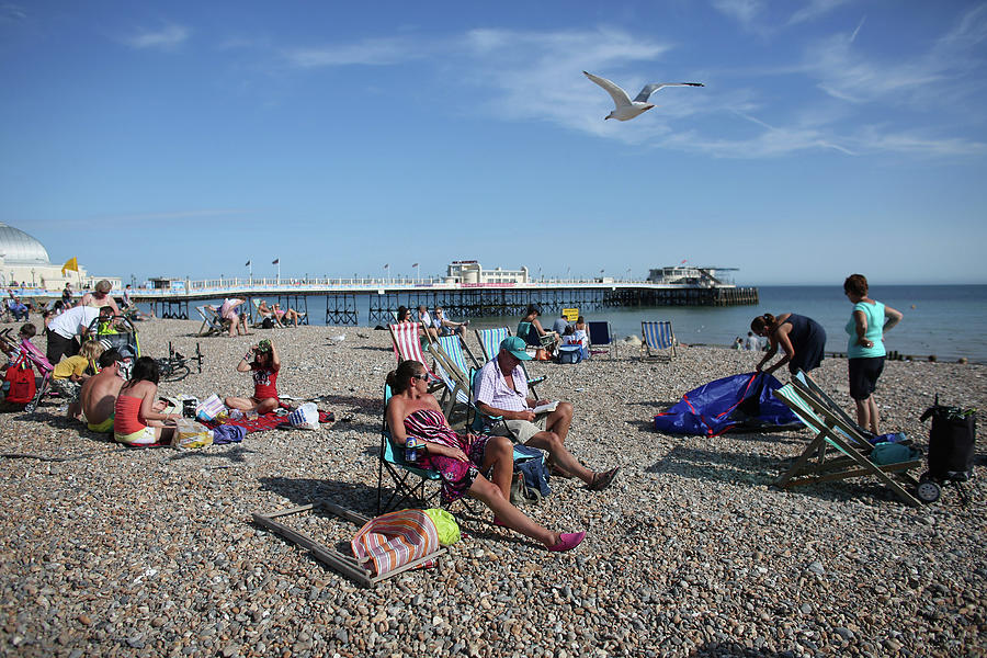 People Enjoy The Warm Weather On The Photograph by Oli Scarff
