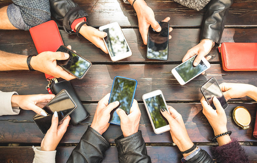 People group having addicted fun together using smartphones - Detail of hands sharing content on social network with mobile smart phones - Technology concept with millennials online with cellphones Photograph by ViewApart