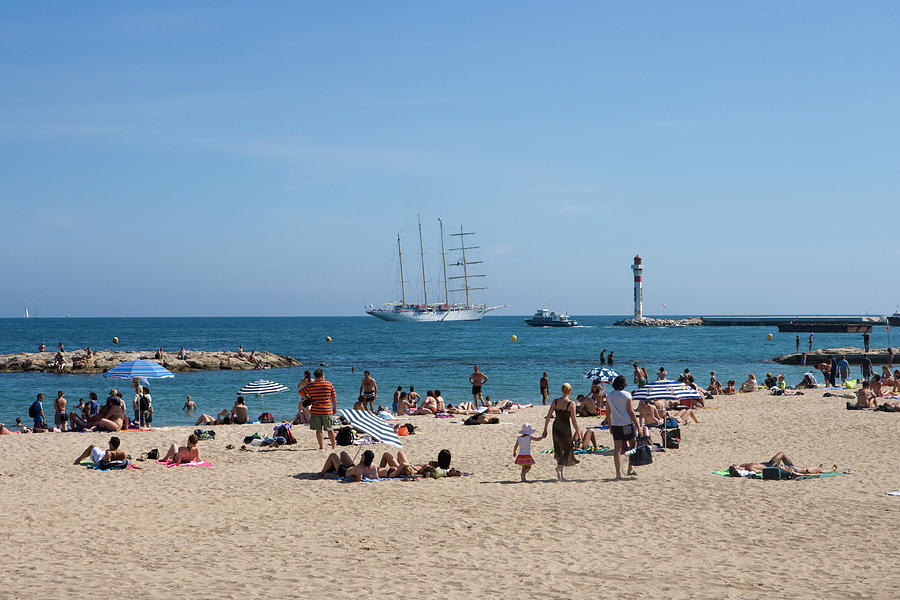 People Sunbathing On Beach With Sailing Photograph by Holger Leue
