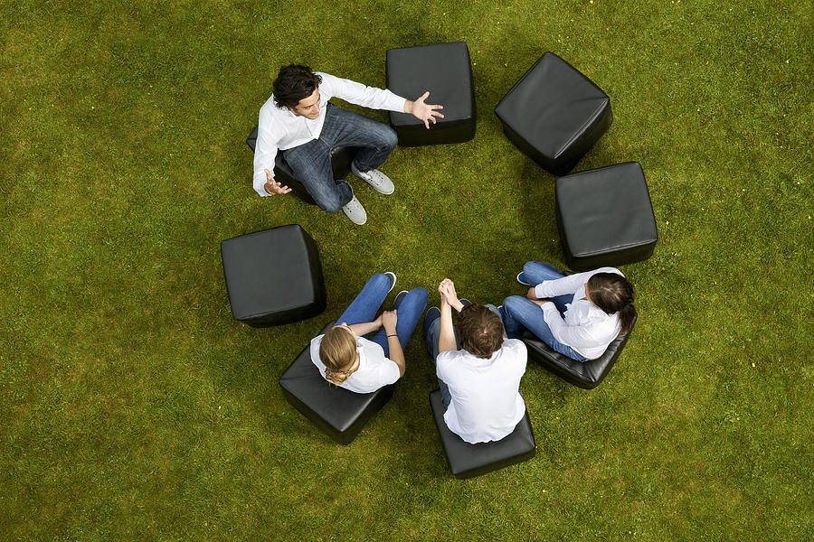 People talking in circle in grass Photograph by Photo_Concepts