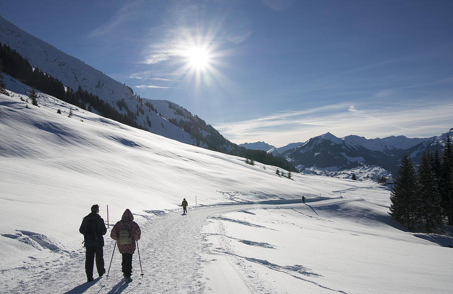 People walking in beautiful sunny winter landscape in the alps with lots of snow Photograph by Matthias Hauser