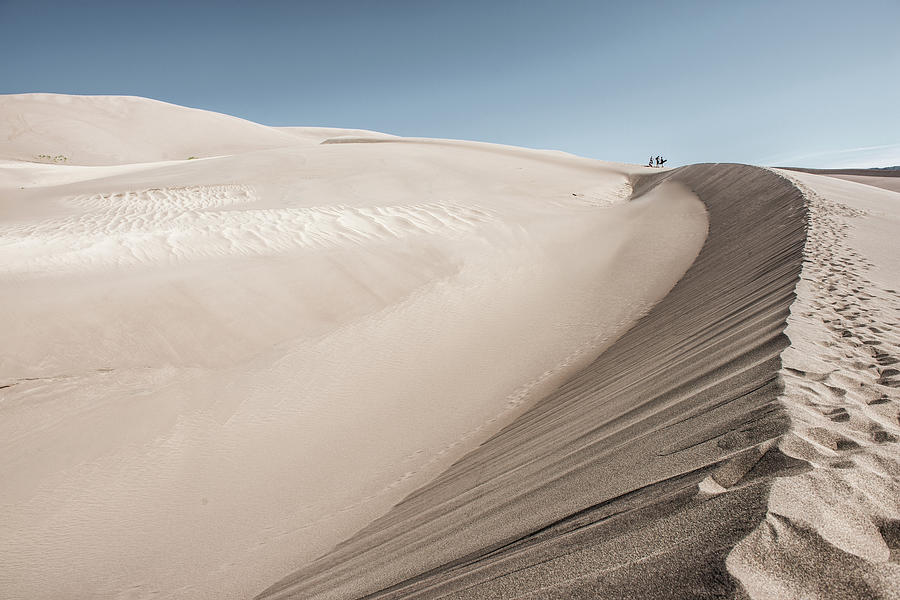 People Walking On A Large Sand Dune Photograph by Tom Olson