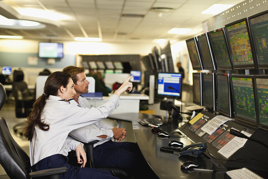 People working in security control room Photograph by Hybrid Images