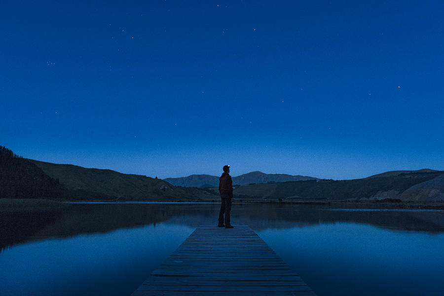 Person on jetty at night Photograph by Johner Images