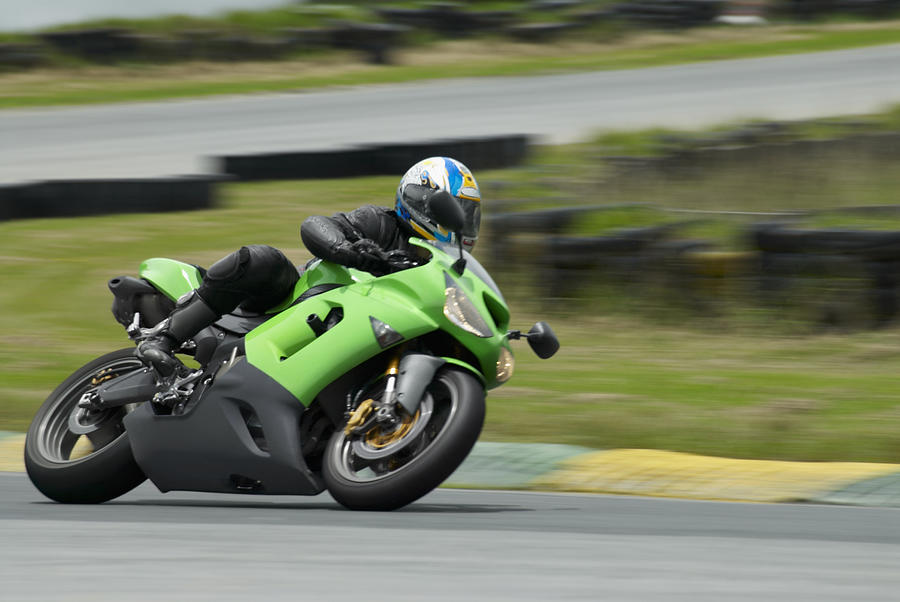 Person riding a motorcycle on a motor racing track Photograph by Glowimages