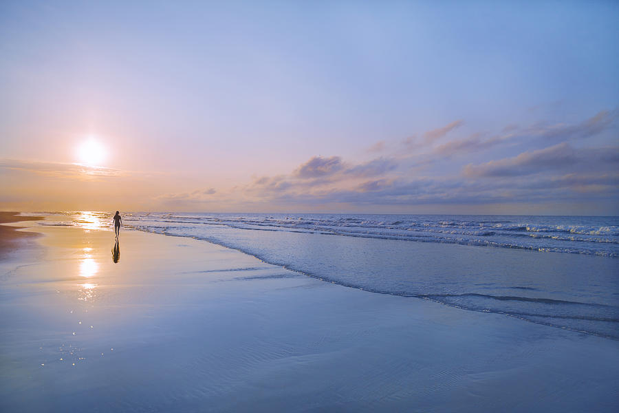 Person walking on beach at sunrise Photograph by Shannon Fagan