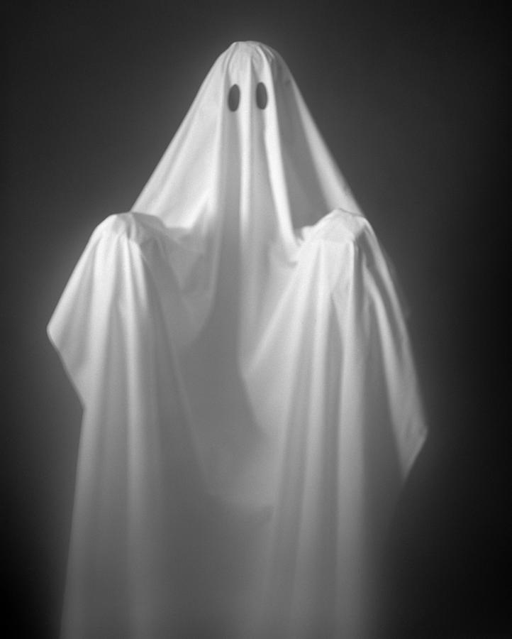 Person Wearing A Ghost Costume, Made Out Of A White Sheet With Two Holes In It. Highlights Are On The Sheet, The Background Is Pitch Black. Photograph by H. Armstrong Roberts