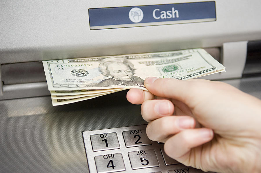 Person withdrawing cash Photograph by Image Source