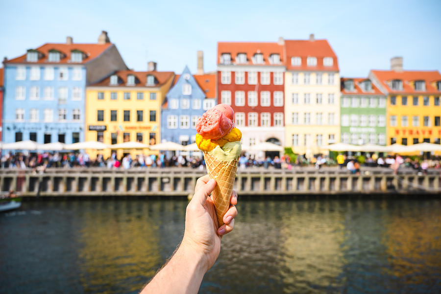 Personal perspective of tourist holding an ice cream in front of Nyhavn canal, Copenhagen Photograph by © Marco Bottigelli