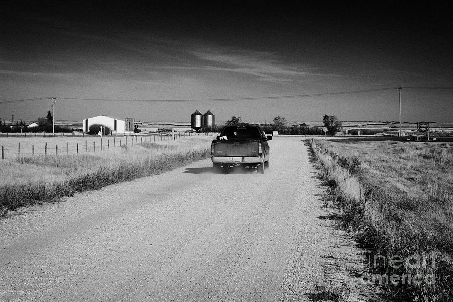 Truck Photograph - pickup truck driving down rough unpaved rural road in farming community Saskatchewan Canada by Joe Fox