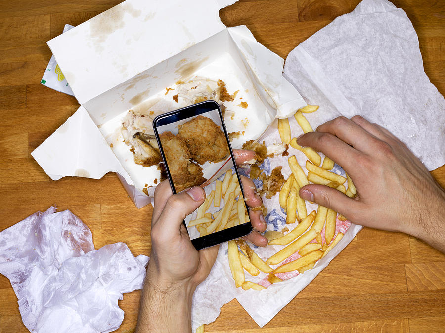 Picture of meal on mobile phone, greasy hands Photograph by Jonathan Knowles