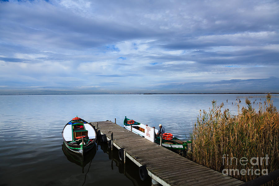 Picturesque view of jetty on Lake Albufera with boats awaiting c Photograph by Peter Noyce