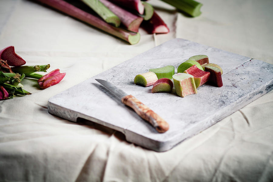 Pieces Of Rhubarb And Knife On Chopping Photograph by Westend61
