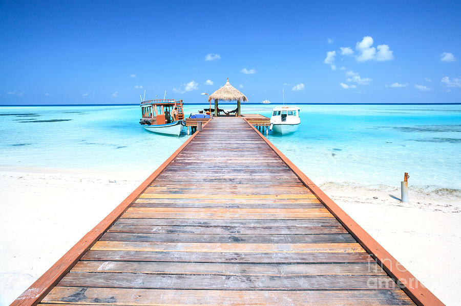 Pier with small hut and traditional boats Indian ocean Maldives Photograph by Matteo Colombo