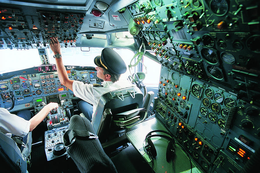 Pilot Switching a Control in the Cockpit of a Commercial Aeroplane Photograph by James Lauritz