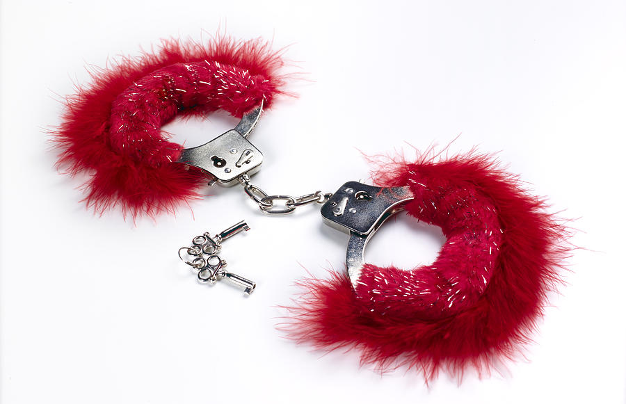 Pink locked handcuffs for adult games Photograph by Peter Dazeley