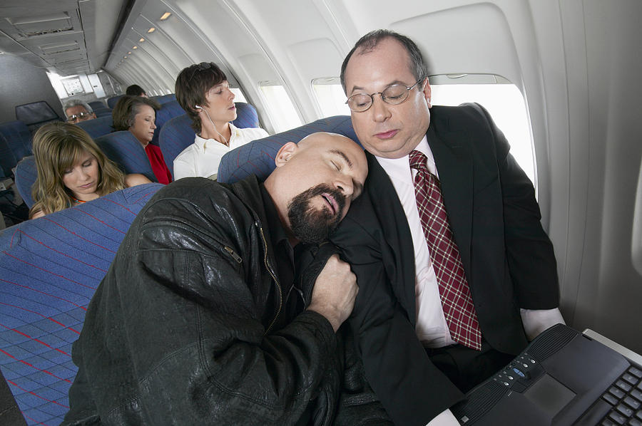 Plane Interior, Man Falling Asleep on the Embarrassed Businessman Next to Him Photograph by Digital Vision.