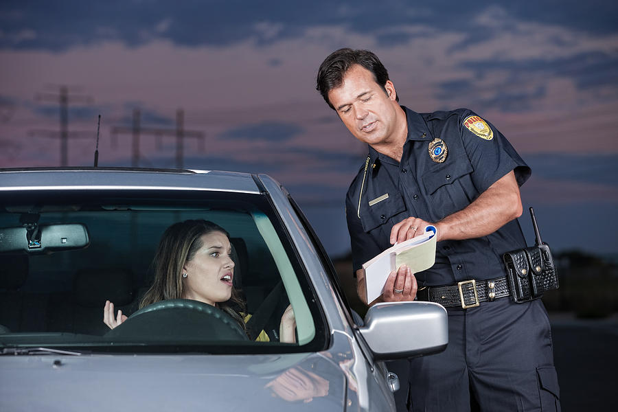 Police Officer Explaining Citation to Woman Driver Photograph by Avid_creative