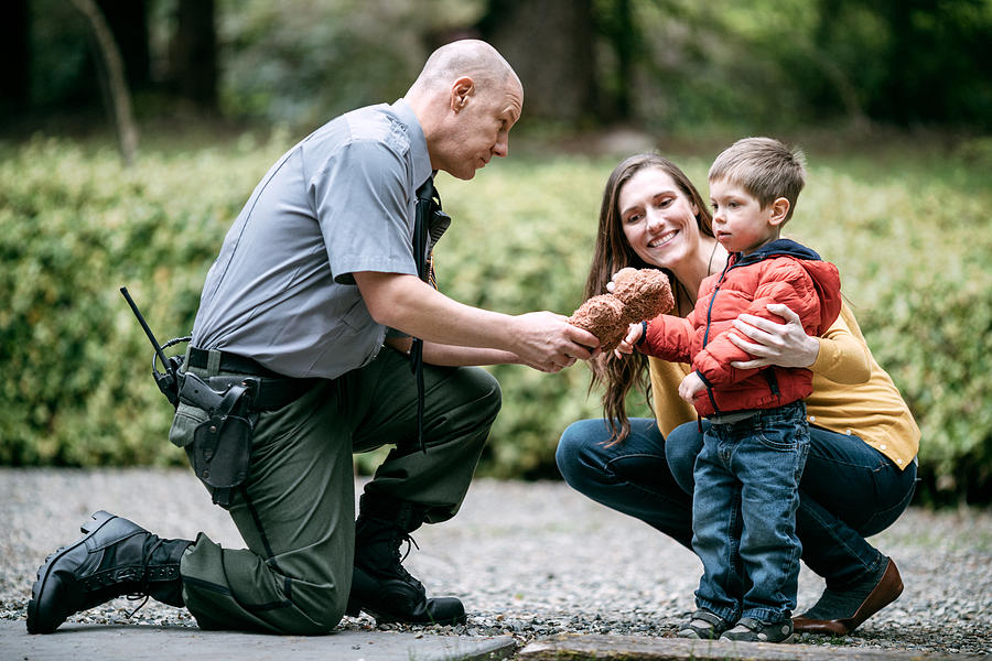 Police Officer Giving Child Stuffed Animal Photograph by RyanJLane