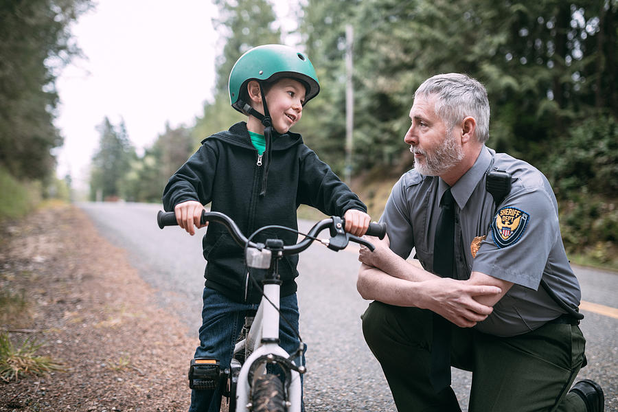 Police Officer Talking to Child on Bike Photograph by RyanJLane