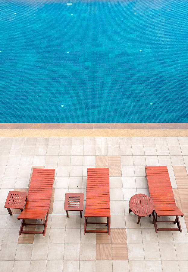Paradise Photograph - Poolside Deckchairs Alongside Blue Swimming Pool by Jirawat Cheepsumol