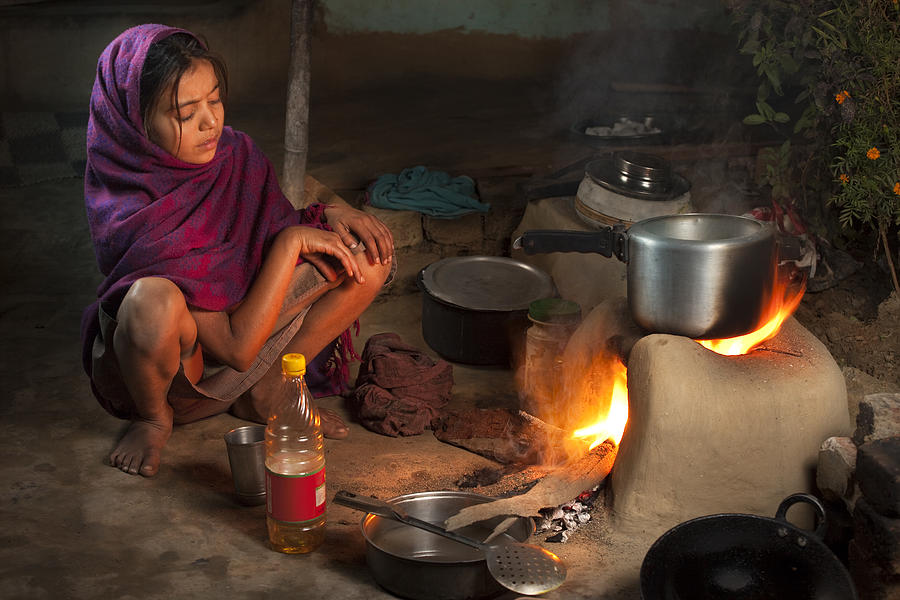 Poor, Indian girl cooking food on a clay stove Photograph by Gawrav