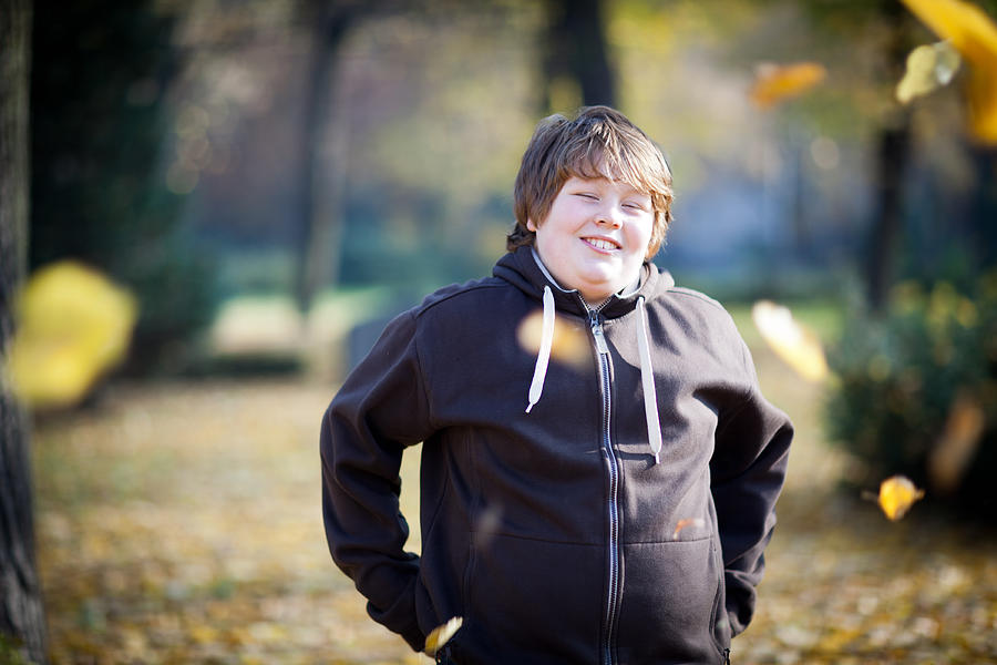 Portrait: Laughing Overweight Boy On Nature Background, Looking At Camera Photograph by Fotografixx