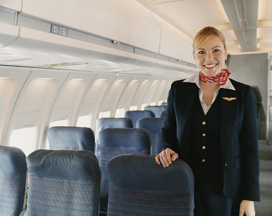 Portrait of a Female Flight Attendant on a Plane Photograph by Digital Vision.
