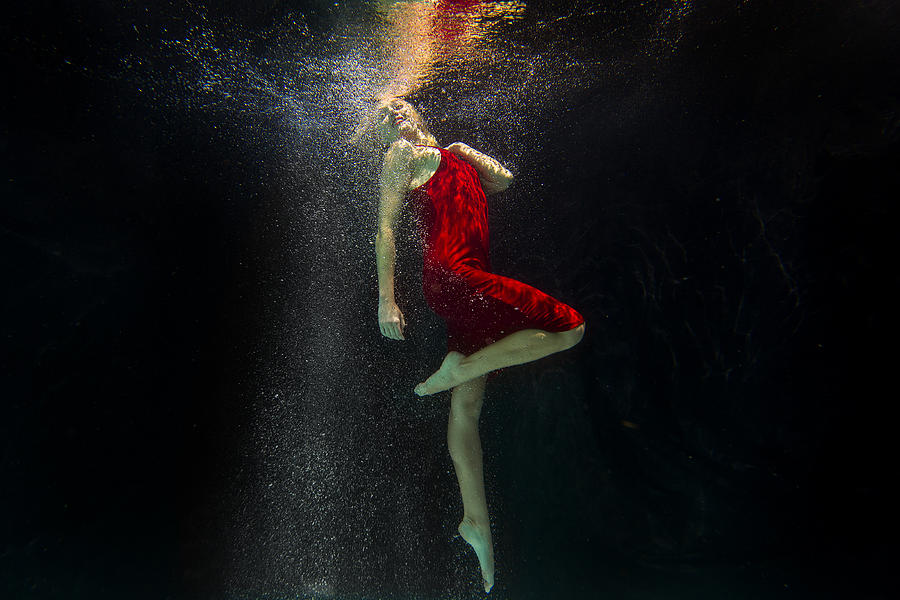 Portrait of a female model underwater in a swimming pool with a black background in San Diego, California. Photograph by K.C. Alfred