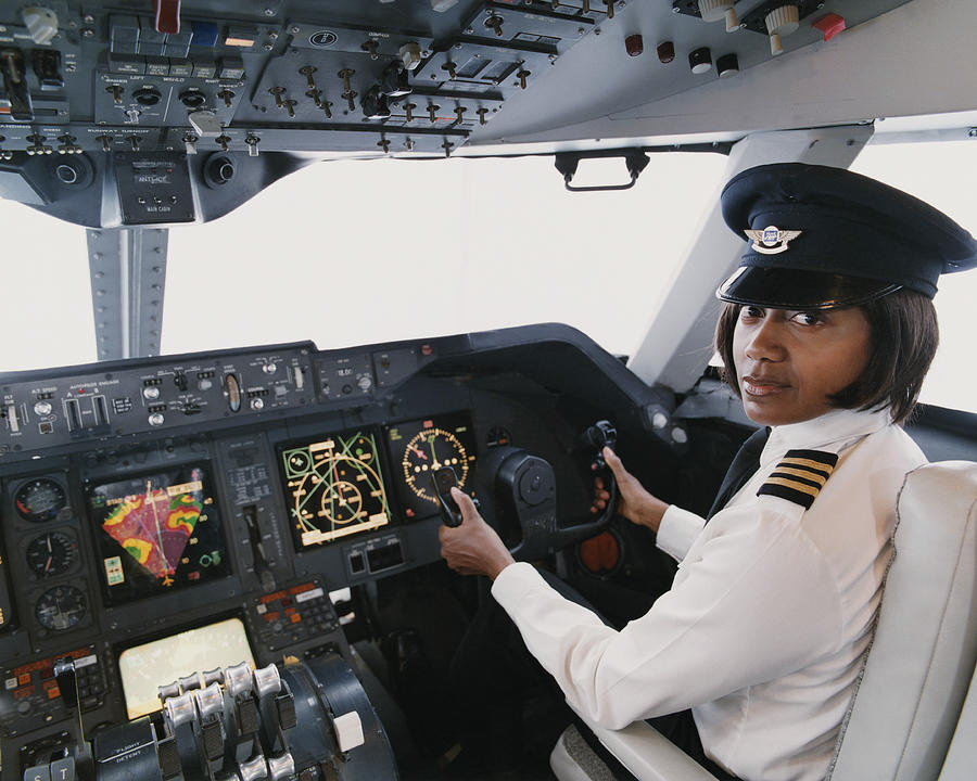Portrait of a Female Pilot Sitting in the Cockpit Photograph by Digital Vision.