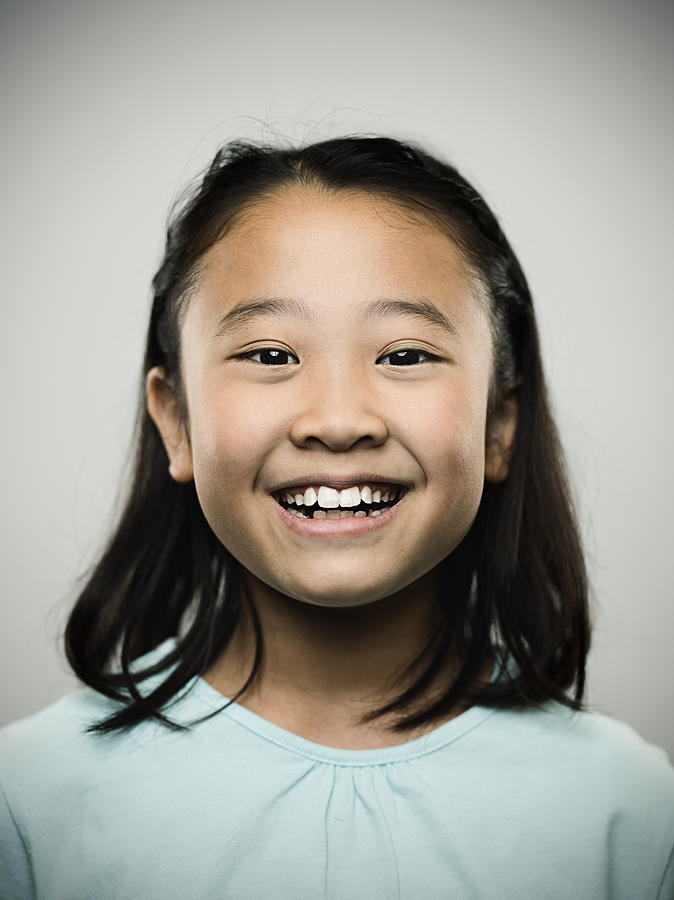 Portrait of a happy young japanese girl looking at camera. Photograph by SensorSpot