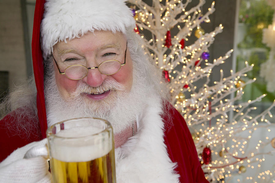 Portrait of a Man in a Father Christmas Outfit Holding a Glass of Beer Photograph by Digital Vision.
