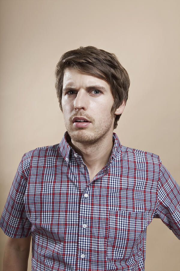 Portrait of a man looking confused, studio shot Photograph by Antenna