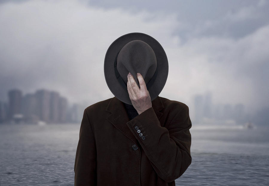 Portrait of a man with face covered by the hat. Photograph by Maciej Toporowicz, NYC