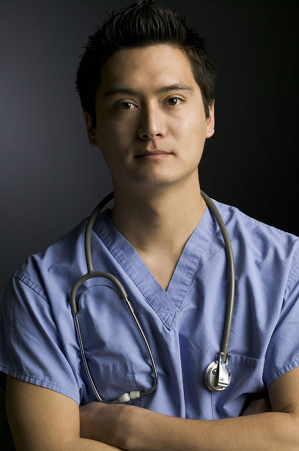 Portrait of a surgeon standing with arms crossed Photograph by Photodisc