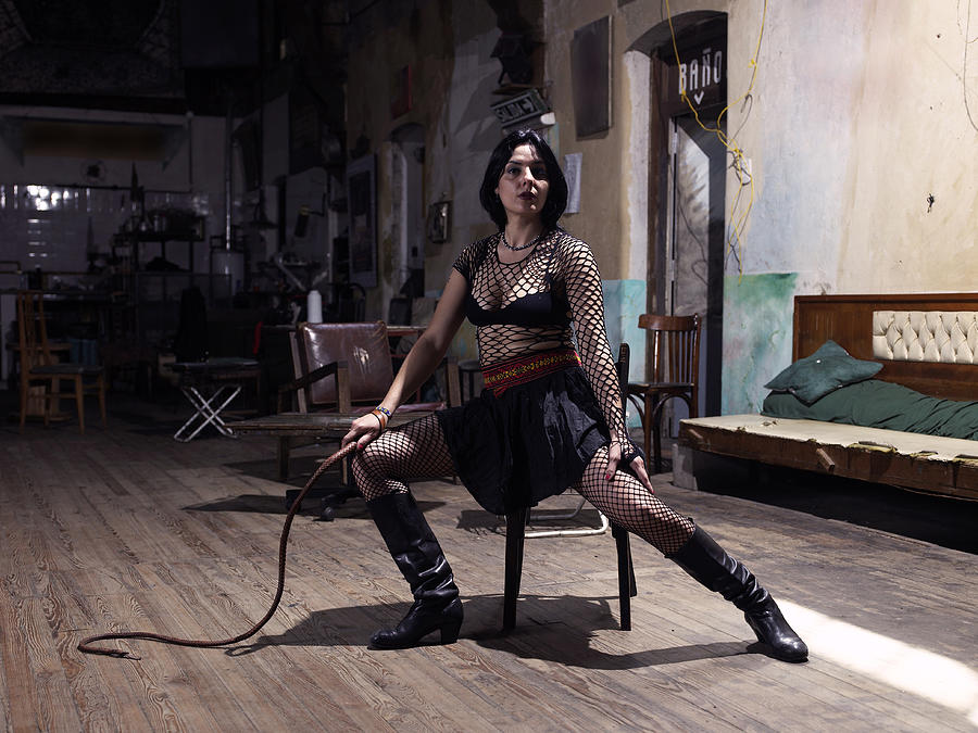 Portrait of a woman holding a whip while sitting on a chair Photograph by WIN-Initiative/Neleman