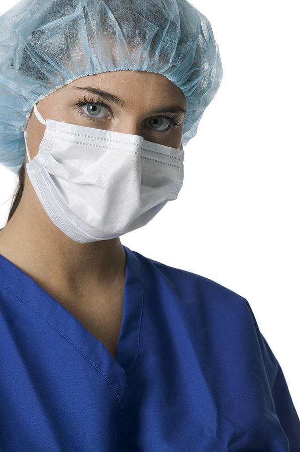 Portrait Of A Young Adult Female In Blue Scrubs And Surgical Mask As She Looks At The Camera Photograph by Photodisc