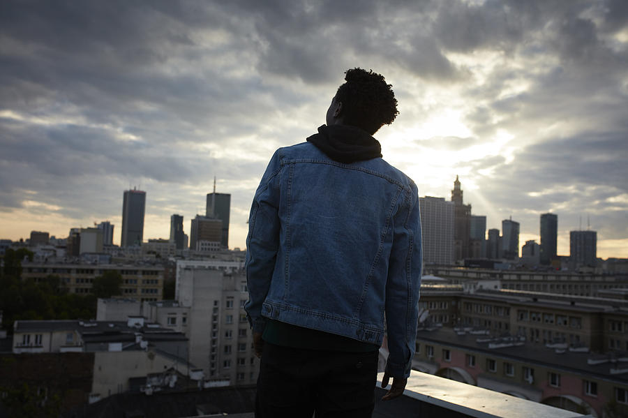 Portrait of a young african man. Urban skyline in background Photograph by Slavemotion