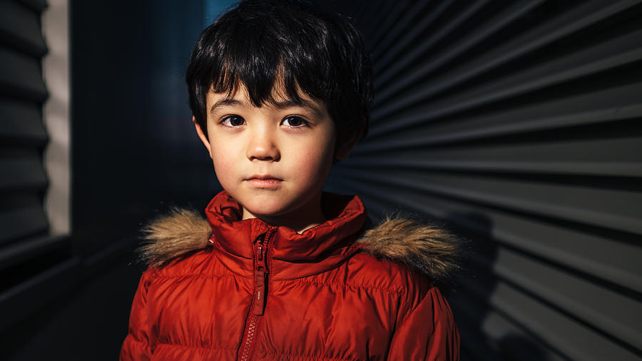 Portrait of a young boy in a dark space Photograph by © Peter Lourenco