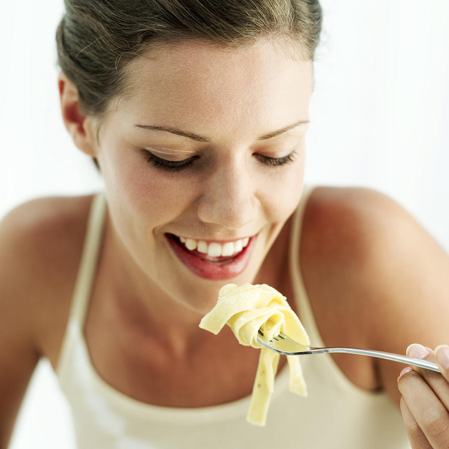 Portrait Of A Young Woman Eating Pasta Photograph by George Doyle