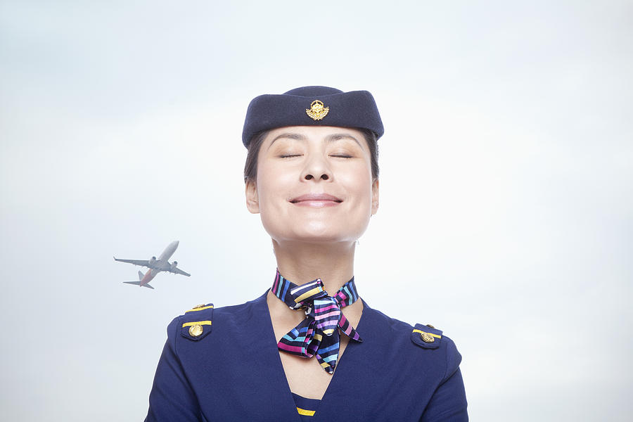 Portrait of air stewardess, eyes closed Photograph by XiXinXing