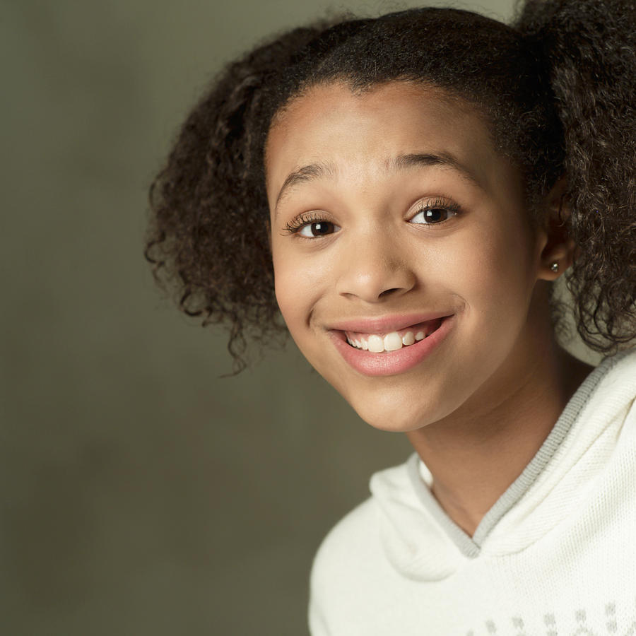 Portrait Of An African American Girl In A A White Sweater As She Brightly Smiles At The Camera Photograph by Photodisc