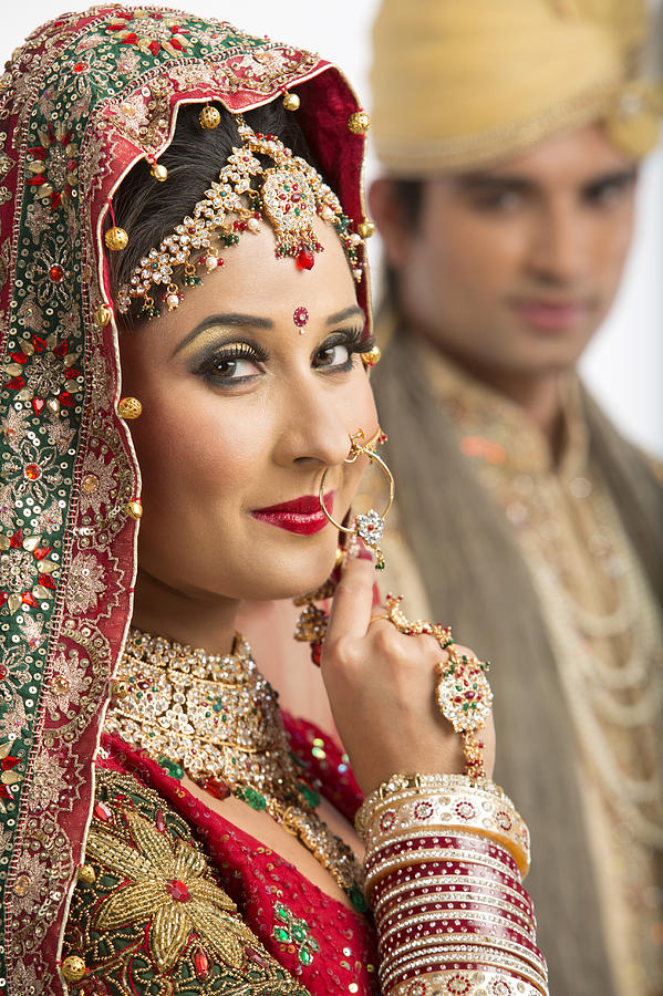 Portrait of an Indian bride posing with her husband in background Photograph by Uniquely India