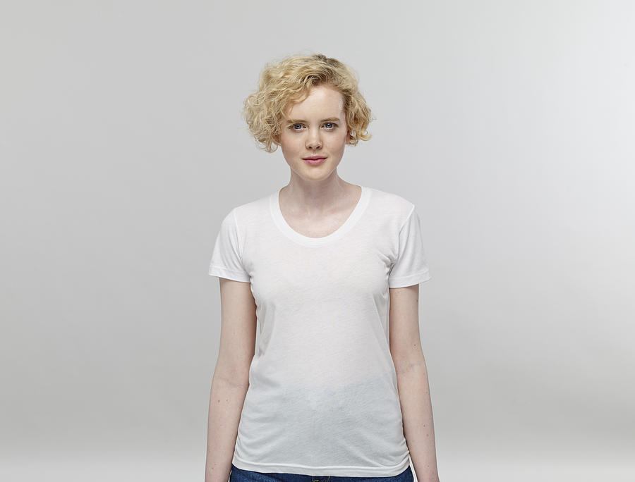 Portrait of blond woman wearing white t-shirt in front of grey background Photograph by Westend61