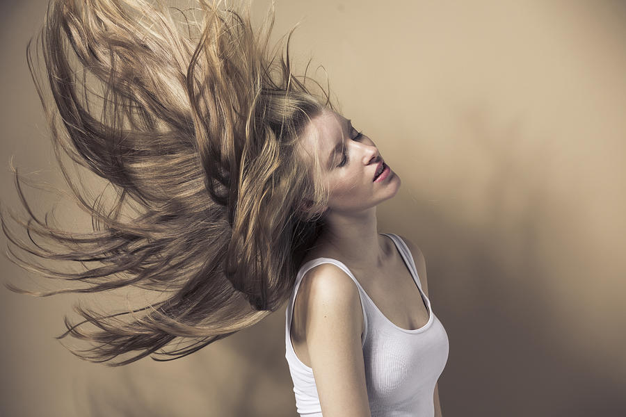 Portrait of blond young woman tossing her hair Photograph by Westend61