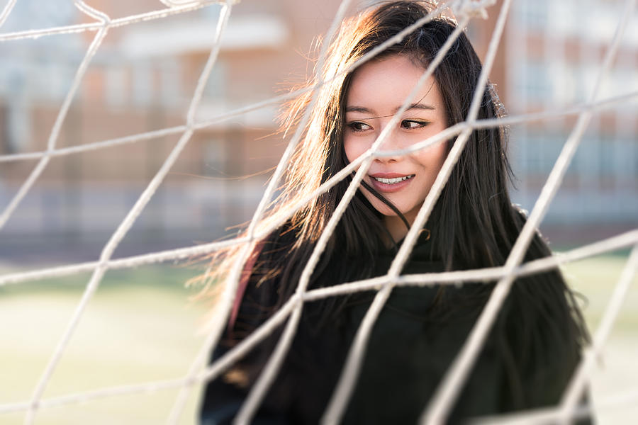 Portrait of confident woman leaning on net . Photograph by Xuanyu Han
