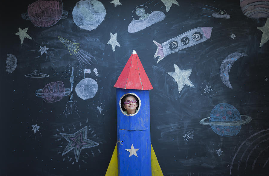 Portrait of girl in handmade space rocket in front of space themed chalk drawings Photograph by Ian Nolan