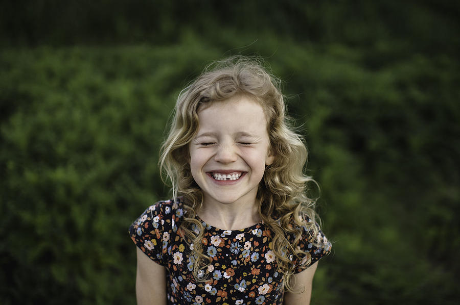 Portrait of girl with wavy blond hair and missing tooth in field Photograph by Erin Lester