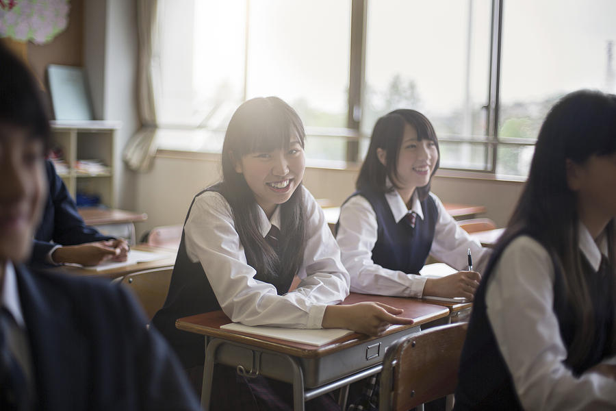 Portrait of happy high school girls in classroom Photograph by Xavier Arnau