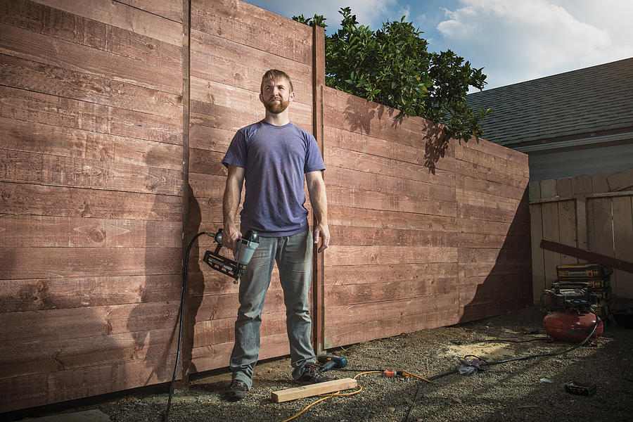 Portrait of joiner in backyard in front of new fence Photograph by Corey Jenkins